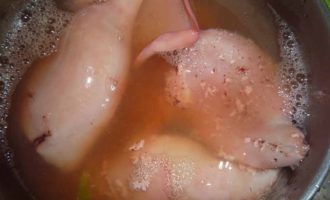 В подсоленную, кипящую воду опускаются тушки кальмаров